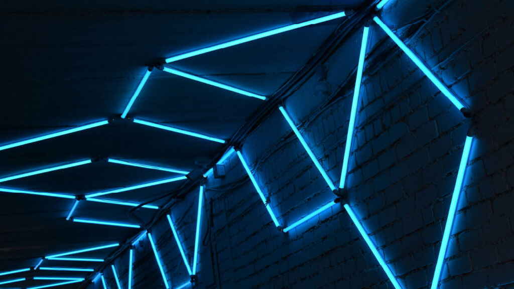 Teal neon lights pattern on brick wall and ceiling