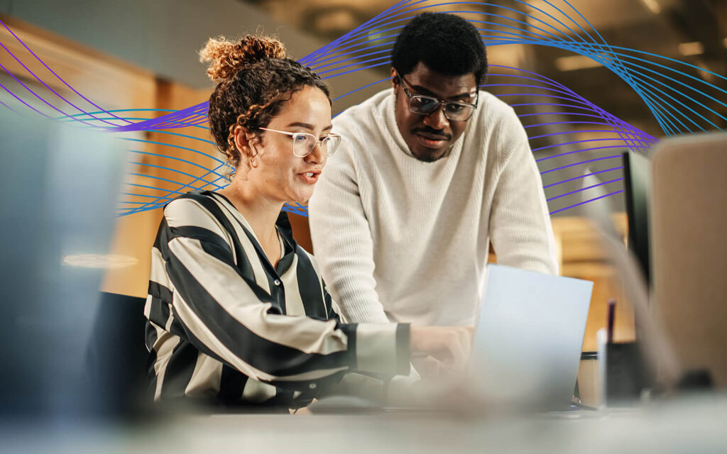 Two people on a laptop with waves in the background