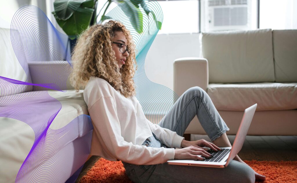 Girl Leaning Against Couch on Floor Working on Computer
