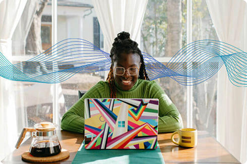A woman works on a laptop at a desk